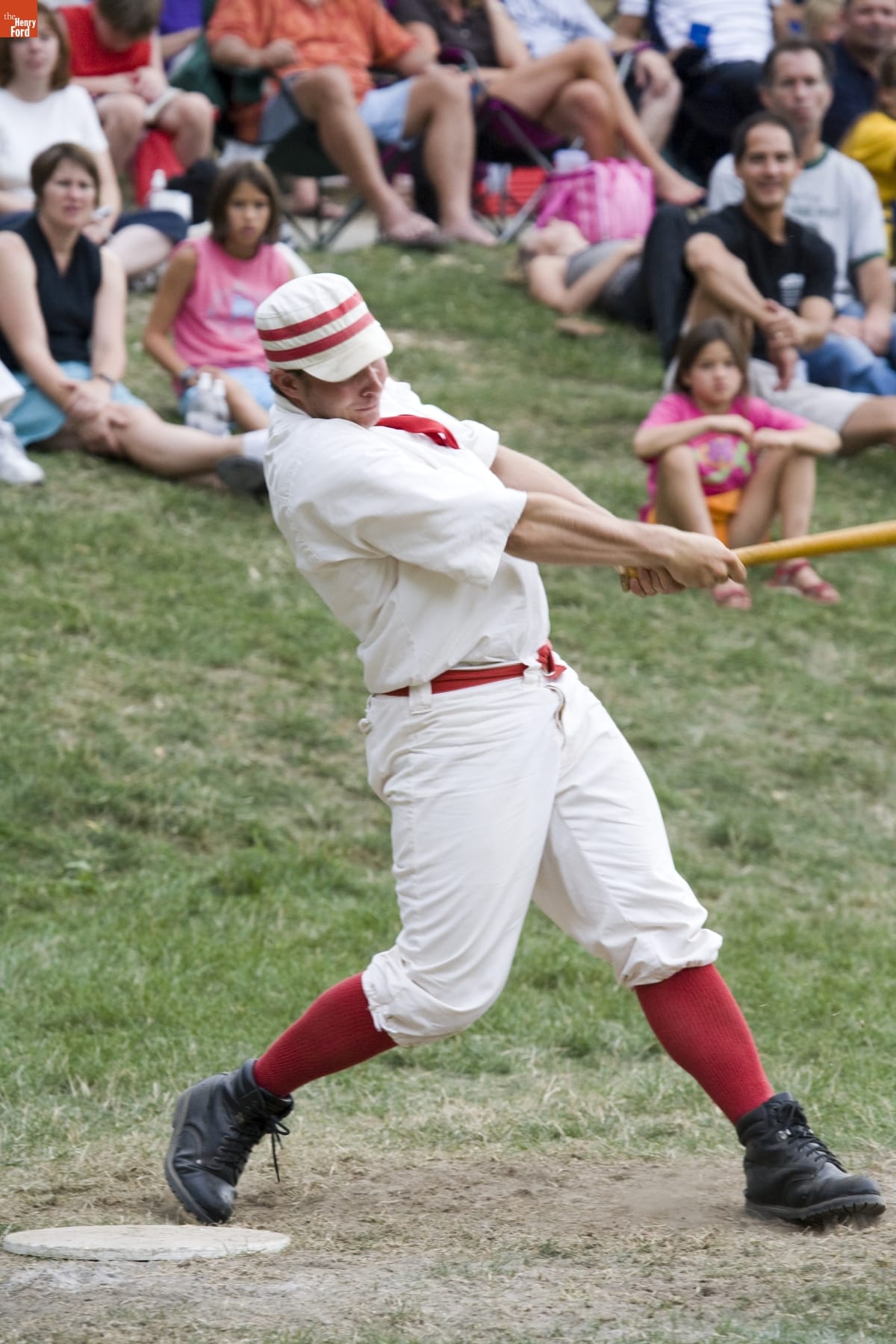 World Tournament of Historic Baseball in Greenfield Village, August 2007 (Photographed by Michelle Andonian) Man in baseball uniform swinging a bat, as crowds watch behind him
