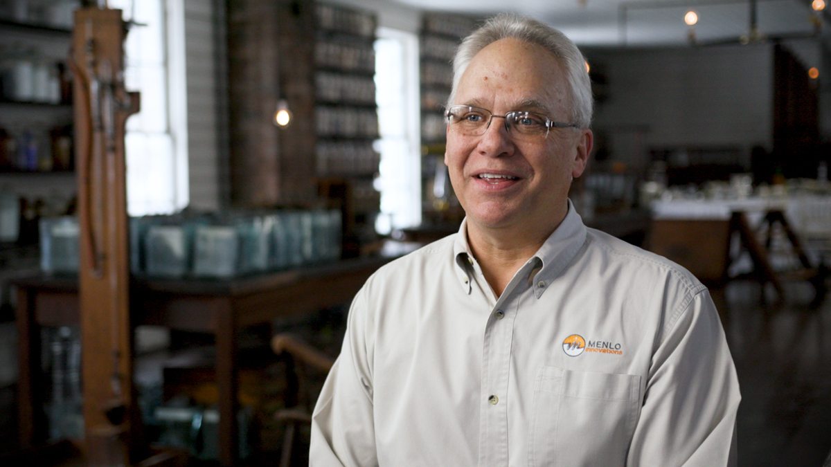 "Growing Up With The Henry Ford" Clip from Interview with Richard Sheridan, November 13, 2019 (screenshot) Man with white hair, white shirt, and glasses sitting in 19th century laboratory