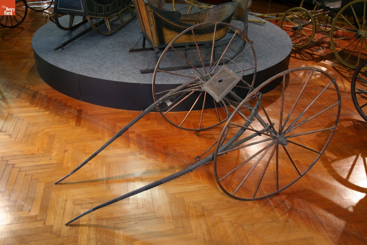 Sulky, circa 1865 Minimal conveyance with two large wheels, rudimentary seat, and bars for attaching to a horse