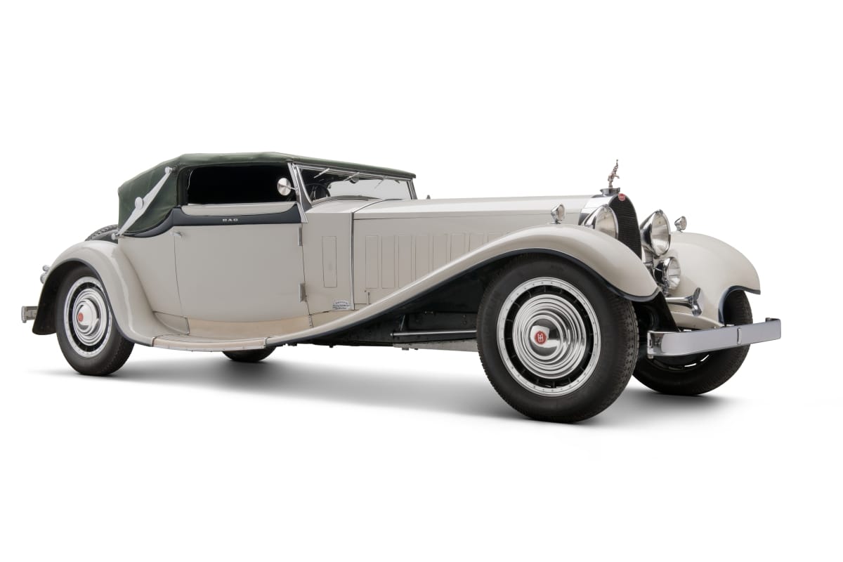 1931 Bugatti Type 41 Royale Convertible Long white car with scrolling style lines and green fabric top