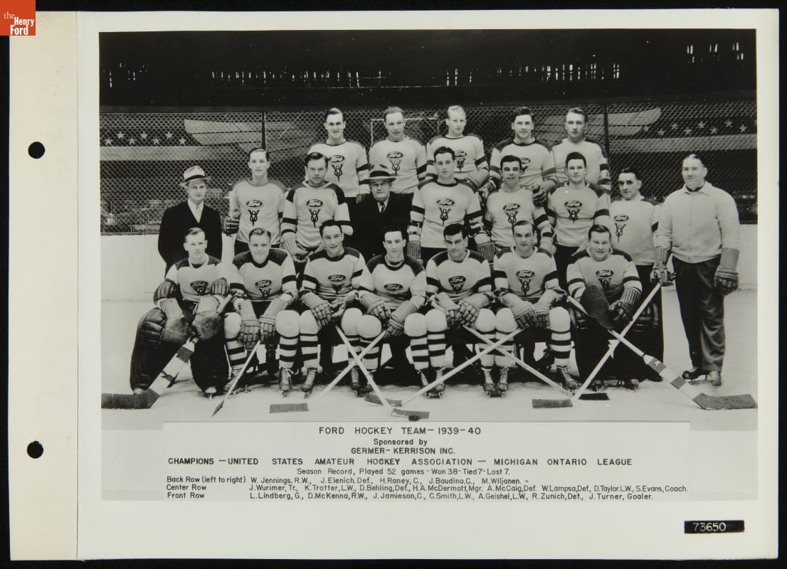 1939-1940 Ford Hockey Team, Sponsored by Germer-Kerrison, April 24, 1940 Group of men, most in hockey uniforms, some with hockey sticks, pose on ice in what appears to be an indoor ice rink