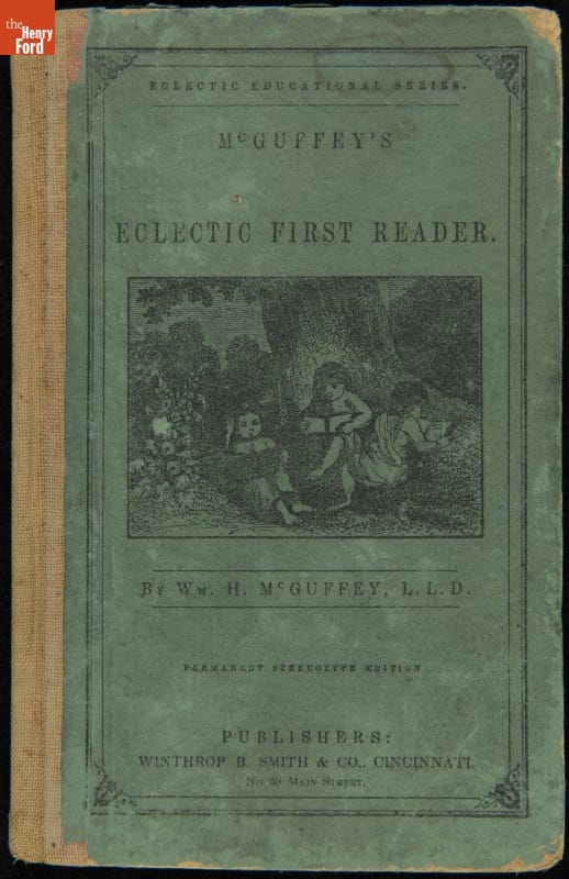 Textbook, "McGuffey's Newly Revised Eclectic First Reader," 1848 Blue book cover with illustration of children reading at the base of a tree; also contains text