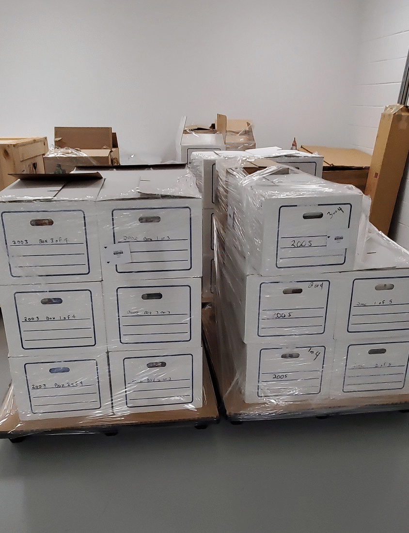 Pallets of incoming unprocessed ornaments in our storage building. GIF showing two views of cardboard boxes shrinkwrapped onto pallets