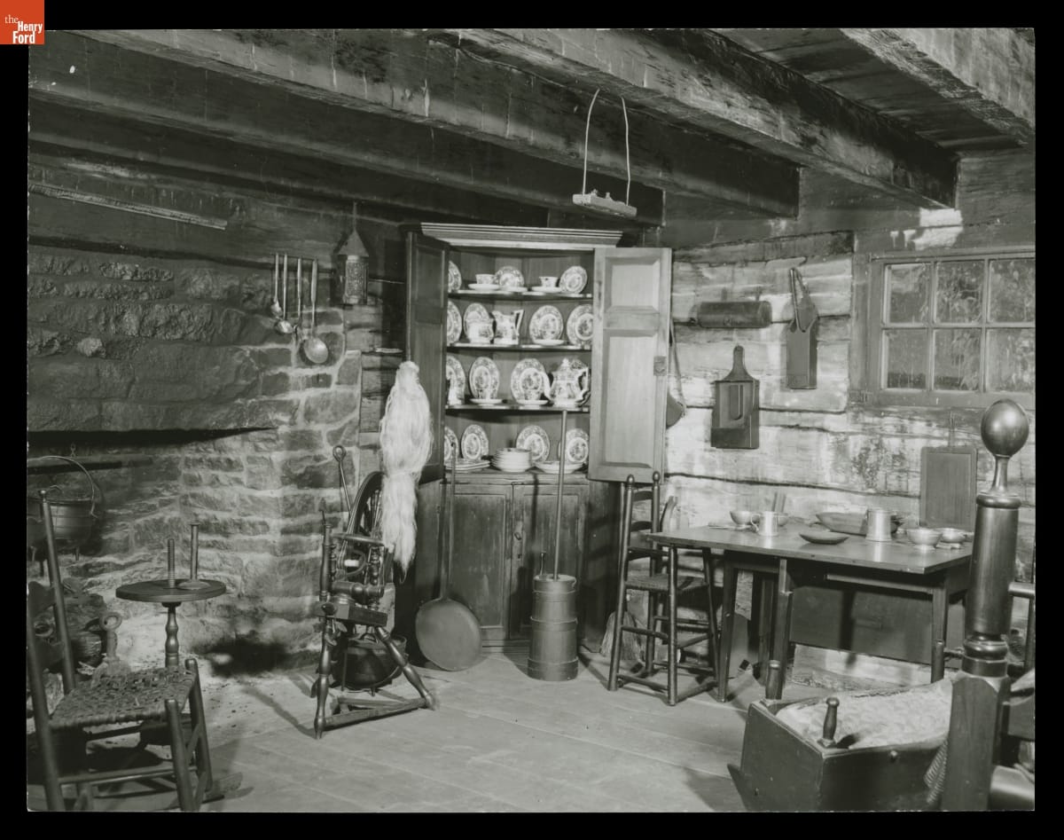 Interior of William Holmes McGuffey Birthplace in Greenfield Village, 1954 Interior of room building with low beamed ceiling, large stone fireplace, and various furniture