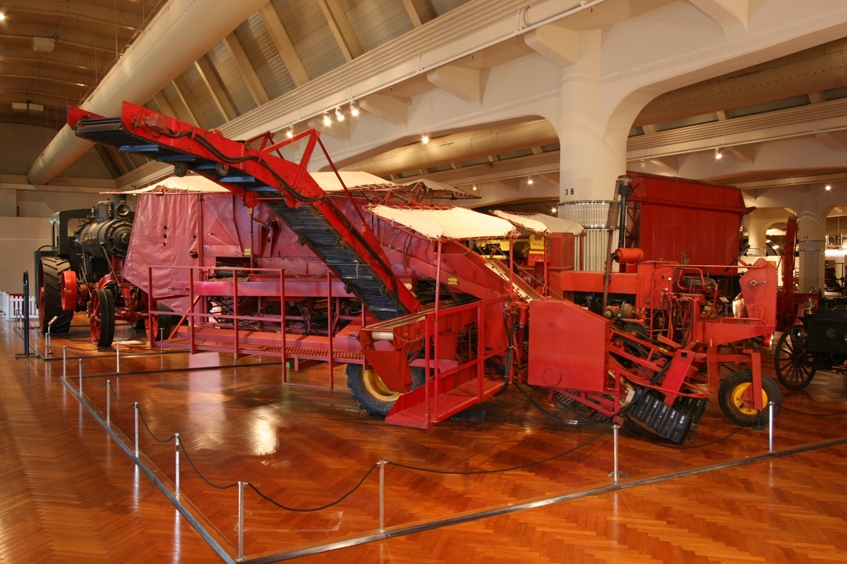 Large red farm machine in museum exhibit