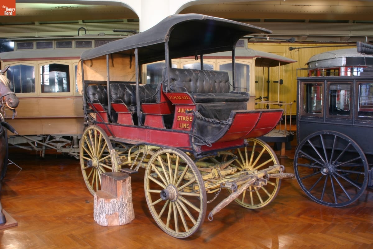 Julian Stage Line Stage Wagon, circa 1900 Red wagon with black cover, open sides, and several rows of seating; also has text on side