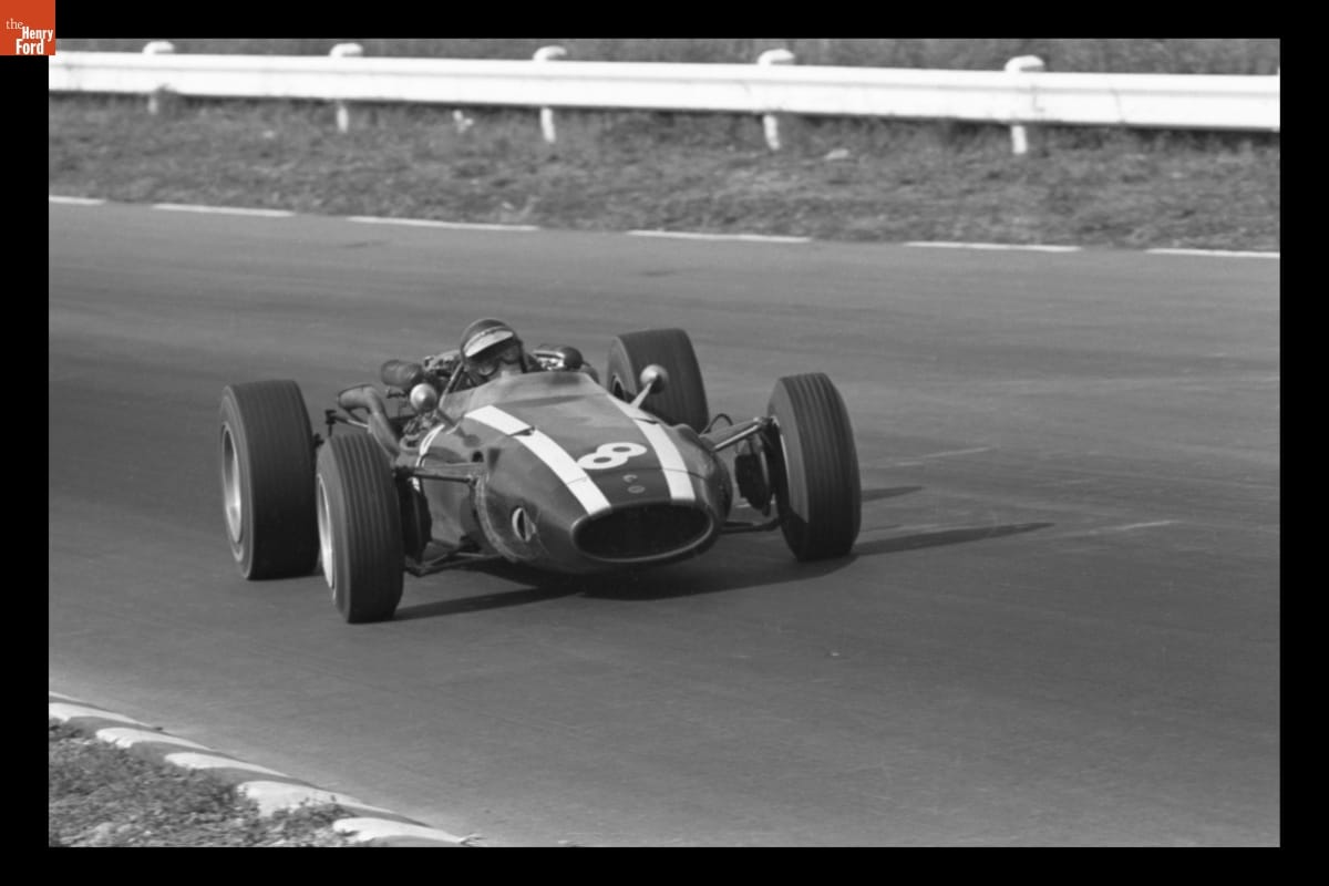 Cooper T81 Driven by Jochen Rindt in the Grand Prix of the United States, Watkins Glen, October 1966 Race car with stripes and diagonal number 8 on hood, and person wearing helmet and goggles inside