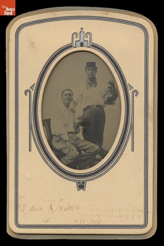 Walt Disney and Ward Kimball Posing in the Greenfield Village Tintype Studio, 1948 Two men, standing one holding a lantern and seated one holding a helmet, pose for a black-and-white photo