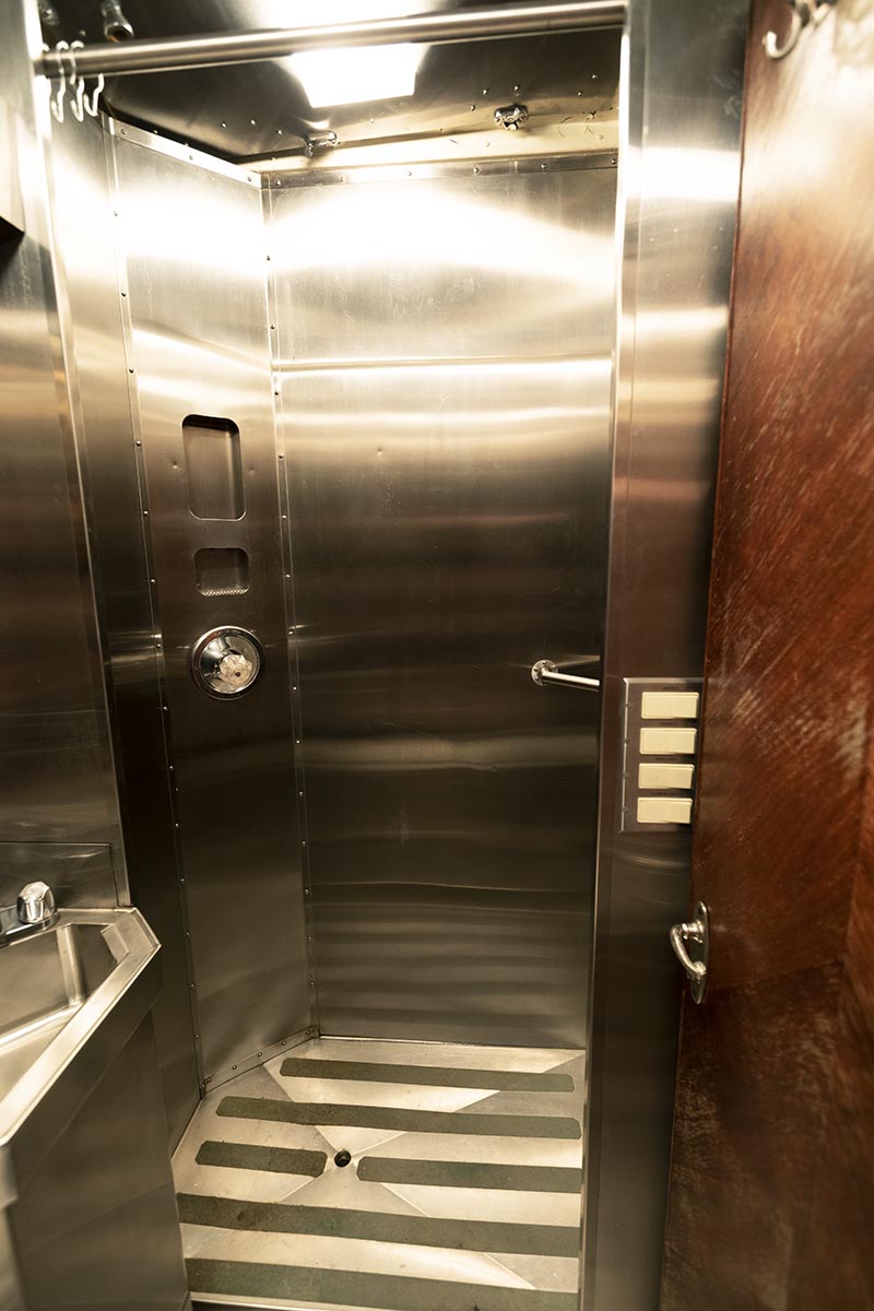 Restroom in the Fair Lane railroad car Stainless steel shower area with sink outside