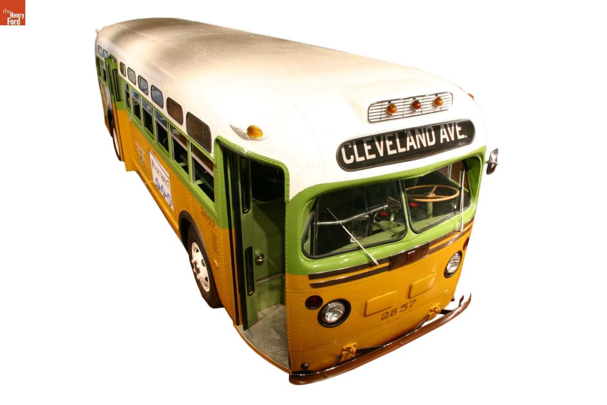 Lime green, mustard yellow, and white bus with sign "Cleveland Ave" on front