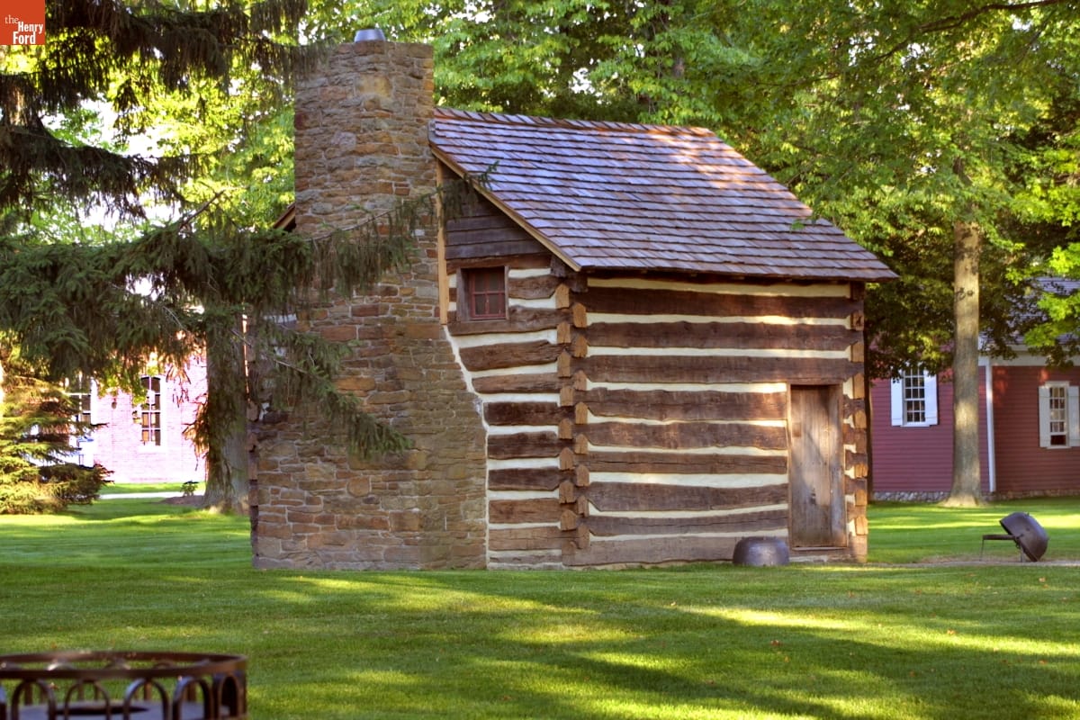 William Holmes McGuffey Birthplace Log cabin on a green lawn with other buildings and trees in background