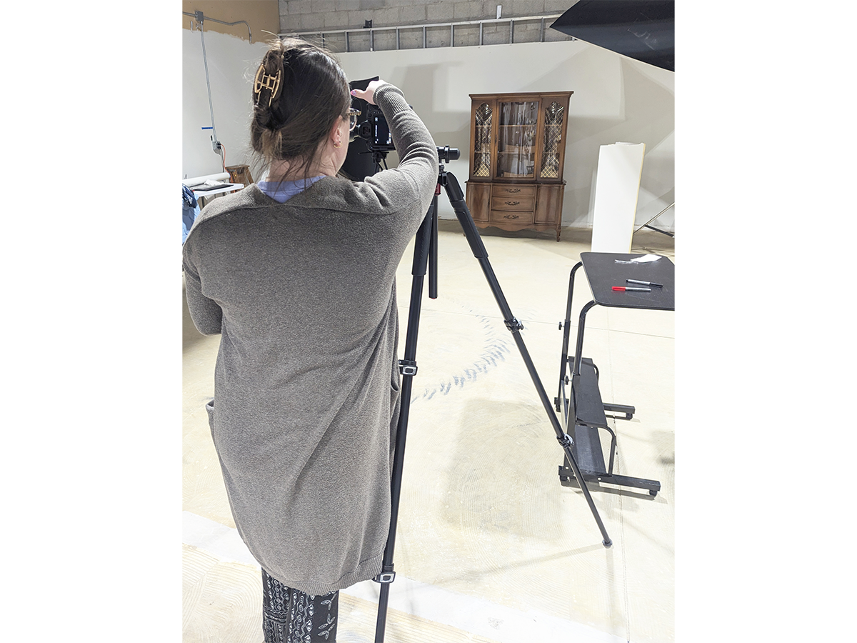 The Henry Ford Photographer Jillian Ferraiuolo, capturing a photograph of a Breakfront China Cabinet from the Jackson Family Home. Digitizing our collection allows artifacts to be accessible, even when not on exhibition. / Photo by Staff of The Henry Ford.